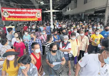  ??  ?? PATIENTLY WAITING: About 300 vendors and employees at Sam Yaek Jedi wet market in Samut Prakan queue up for Covid-19 testing after infections were linked to the market. The market was ordered closed for three days.