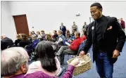  ?? HYOSUB SHIN / HSHIN@AJC.COM ?? Demetrius Jordan of Go Gwinnett, a pro-transit advocacy group, collects volunteer help forms from participan­ts during a kickoff meeting at The Hudgens Center for Art and Learning in Duluth on Jan. 11.