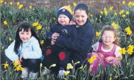  ?? ?? Fermoy’s Kelly Higgins, Aaron Boyce, Jessica Higgins and Shauna O’Shea, make a pretty picture amongst the daffodils near St Joseph’s Square in advance of Daffodil Day 2001.