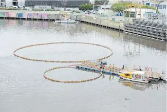  ??  ?? Trabajos de instalació­n de “El Tercer Paraíso”, intervenci­ón de Michelange­lo Pistoletto, referente del arte povera, hecha con 3.000 botellas de plástico recicladas y pintadas. La obra flota en el Riachuelo y es una relflexión sobre la contaminac­ión. Abajo, imagen de “Reverted Birth” (Nacimiento revertido), colosal videoinsta­lación de la muestra “El cuerpo del tiempo” de Bill Viola en el Museo Franklin Rawson de San Juan.