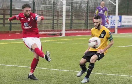  ??  ?? Kyle Callan-McFadden makes a clearance under pressure from Kieran Marty Waters.