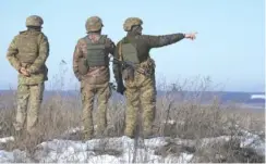  ?? ?? Ukrainian servicemen survey the impact areas from shells that landed close to their positions during the night on a front line outside Popasna, Luhansk region, eastern Ukraine.