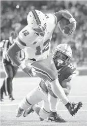  ?? MADDIE MEYER/GETTY-AFP ?? Boston College’s Isaiah McDuffie tackles Miami quarterbac­k Malik Rosier on Friday night.