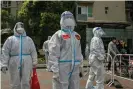  ?? Héctor Retamal/AFP/Getty Images ?? Workers and volunteers arrive to begin testing in a residentia­l compound in Jing’ an district in Shanghai on Friday. Photograph: