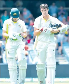  ??  ?? Australia’s batsman Tim Paine (L) and Pat Cummins walk off the field at lunch during day five of the first Test cricket match between Australia and India. - AFP photo