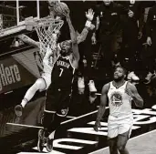  ?? Sarah Stier / Getty Images ?? Kevin Durant soars to 22 points in 25 minutes in his first game in 18 months and his successful debut with the Nets against his former Warriors teammates.