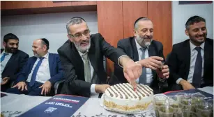  ?? (Marc Israel Sellem/The Jerusalem Post) ?? DEPUTY JERUSALEM Mayor Tzvika Cohen cuts a cake next to Shas head Arye Deri at the opening of the party’s headquarte­rs yesterday.