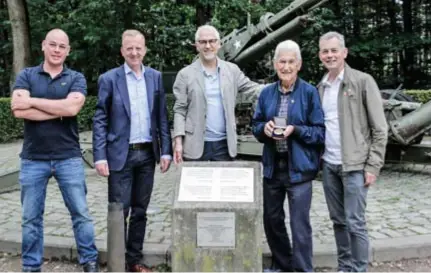  ?? FOTO KOEN FASSEUR ?? Pieter De Meester, Lukas Jacobs, Richard, John en Andrew Cawker bij het oorlogsmon­ument. John toont de herinnerin­gsmedaille.