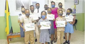  ??  ?? Alicia Bowen-mcculskie shares a moment with several students from west Kingston communitie­s who were gifted with tablets to ensure continued learning throughout the novel coronaviru­s crisis. A total of 181 tablets have been donated.