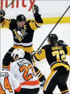  ?? THE ASSOCIATED PRESS FILE ?? Penguins captain Sidney Crosby raises his arms in celebratio­n with Patric Hornqvist, right, after scoring the game-winning goal in overtime during a Penguins win over the Flyers last Nov. 27 at PPG Paints Arena in Pittsburgh. The teams meet there...