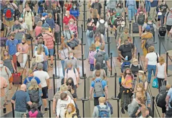  ?? AP PHOTO/DAVID ZALUBOWSK ?? Travelers queue up in long lines to pass through the south security checkpoint June 16 at Denver Internatio­nal Airport in Denver.