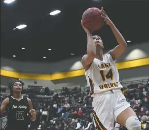  ?? The Sentinel-Record/Grace Brown ?? IN FRONT: Lake Hamilton senior Nya Moody (14) puts in a fast break layup ahead of Hot Springs sophomore Kalariya McDaniel (12) Friday during the Lady Wolves’ 44-32 victory at Wolf Arena in Pearcy.