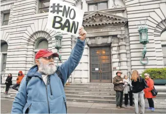  ?? JOHN G. MABANGLO, EUROPEAN PRESSPHOTO AGENCY ?? A protester stands outside the U. S. Court of Appeals for the 9th Circuit in San Francisco in February as legal wrangling began.