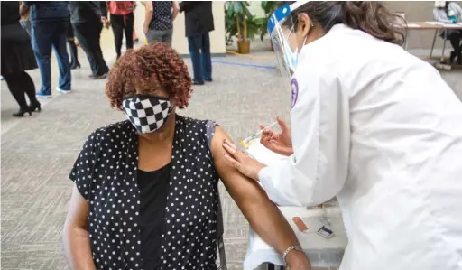  ?? ANTHONY VAZQUEZ/SUN-TIMES ?? Eddie Mae Ferguson receives her first COVID-19 vaccinatio­n shot Thursday at Garden House Apartments in Maywood.