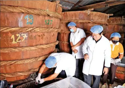  ?? COMMERCE MINISTRY ?? Commerce minister Pan Sorasak (second from left) brings a delegation of the Korea Importers Associatio­n (KOIMA) to a Ngov Heng fish sauce production facility on December 3.