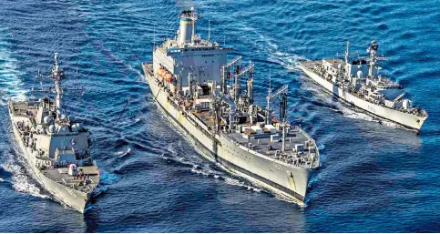  ??  ?? HMS Argyll, right, at sea with the replenishm­ent vessel USNS Henry J Kaiser as it transfers supplies to the destroyer USS Mccampbell while on operations in the South China Sea