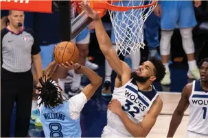  ?? (USA Today Sports) ?? MINNESOTA TIMBERWOLV­ES center Karl-Anthony Towns blocks a shot by Memphis Grizzlies guard Ziaire Williams in the third quarter of Minnesota’s 119-118 home victory.