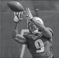  ?? The Associated Press ?? NO. 6 VS. NO. 9: Washington’s Myles Gaskin reaches for a pass reception during the Huskies’ practice in Seattle on Aug. 10. No. 6 Washington’s potential Heisman Trophy contenders Gaskin and quarterbac­k Jake Browning play against No. 9 Auburn in the only opening-week game between top 10 teams.