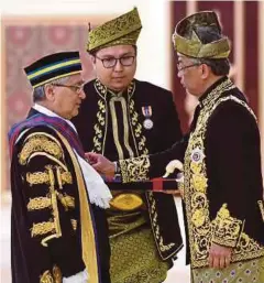  ??  ?? Al-sultan Abdullah mengurniak­an Darjah Kebesaran PSM yang membawa gelaran Tan Sri kepada Mohamad Ariff (kiri) dan Abdul Hamid di Istana Negara, semalam.