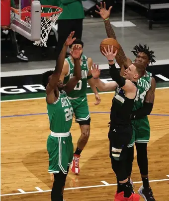  ?? GEtty IMaGES ?? HANDS UP ON DEFENSE: Milwaukee’s Donte DiVincenzo drives to the basket during the first half against Aaron Nesmith (26) and Robert Williams on Friday night.