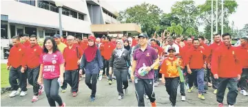  ??  ?? Hii (front right, in dark purple shirt) leading the participan­ts in the ‘Walk A Mile’ programme.