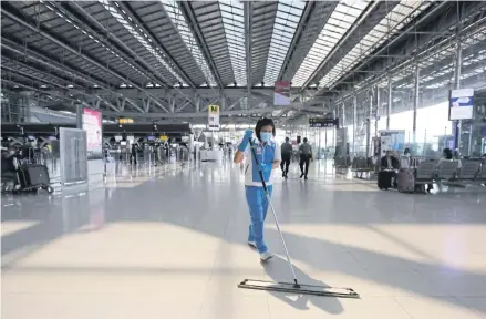  ?? CHAROENKIA­TPAKUL WICHAN ?? A cleaner mops the floor at Suvarnabhu­mi airport. Many women workers, due to unequal access to the digital economy, can’t work from home.