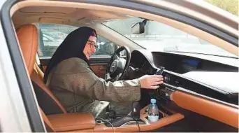  ?? AFP ?? Newly licensed Reem Farahat, an employee of Careem, prepares for a customer shuttle using her car in the Saudi capital Riyadh on Sunday.