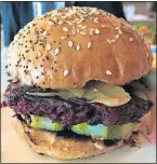  ??  ?? The veggie burger at Red Rooster Bar is founded on a beet-black bean patty.