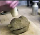  ??  ?? A British schoolchil­d stamps a logo into a piece of clay at the Coming World Remember Me workshop in Ypres, Belgium on Monday.