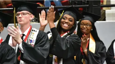  ?? ?? Honor students Ethan Johnson (from left), Denim Banks and Sharae Gipson applaud their classmates as they receive diplomas from Watson Chapel High School.