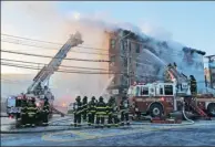  ?? SETH WENIG / ASSOCIATED PRESS ?? Firefighte­rs work to contain a blaze in the Bronx, New York, on Tuesday.