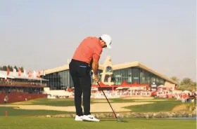  ?? Matthew Lewis / Getty Images ?? Rory McIlroy fires toward the 18th hole at Abu Dhabi Golf Club.