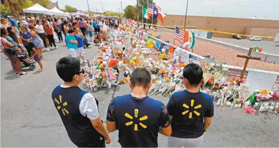  ??  ?? Empleados del Walmart donde el sábado pasado ocurrió la masacre de 22 personas acudieron al memorial colocado afuera de la plaza comercial Cielo Vista, en El Paso, Texas.