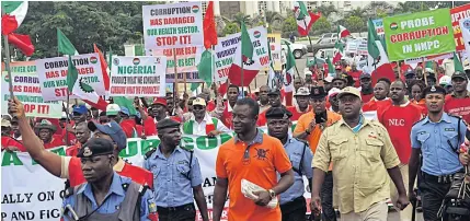  ?? AFP ?? Workers carry banners and march in support of a government anti-corruption drive during a rally in Abuja, on Sept 10, 2015. Daily blackouts are short-circuiting efforts to promote investment in the country.