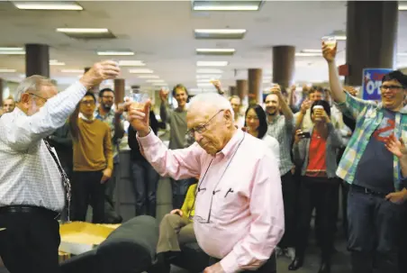  ?? Mike Kepka / The Chronicle 2015 ?? Veteran reporters Carl Nolte and David Perlman in 2015 lead the newsroom in a toast to The Chronicle’s first 150 years.