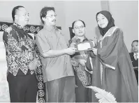  ??  ?? TAHNIAH: Dr Hazland menyampaik­an anugerah kepada pelajar SMK Bako sambil disaksi tetamu kehormat lain.