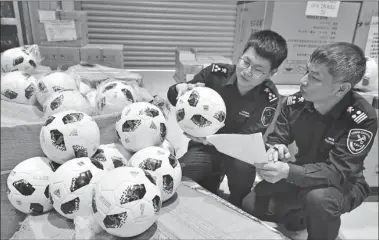  ?? LYU / CHINA DAILY ?? Customs officials seize 300 footballs in Yiwu, Zhejiang province on Tuesday, which carry the trademark “Russia 2018” related to the 2018 FIFA World Russia without authorizat­ion.