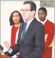  ?? Arnold Gold / Hearst Connecticu­t Media ?? Wilbur Cross High School principal Edith Johnson, left, and New Haven Superinten­dent of Schools Carol Birks listen to Gov. Dannel P. Malloy announce 2017 statewide graduation statistics at Wilbur Cross High School in New Haven on Monday.