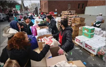  ?? NANCY LANE — BOSTON HERALD ?? People pick up provisions at the Salvation Army Chelsea Corps Community Center on Thursday.