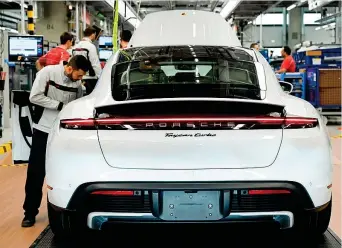  ??  ?? Anche elettrica
Un operaio Porsche al lavoro su Taycan, il primo modello elettrico del gruppo
