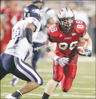  ?? SUN FILE (2006) ?? UNLV’S Ryan Wolfe gains yardage while pursued by UNR’S Nick Hawthorne in a 2006 game. Wolfe and 10 others will be inducted into the UNLV Athletics Hall of Fame during ceremonies tonight.
