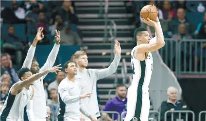  ?? AP FOTO / CHUCK BURTON ?? CHEERERS. San Antonio Spurs players reacts as Danny Green, takes a 3-point shot against the Charlotte Hornets.