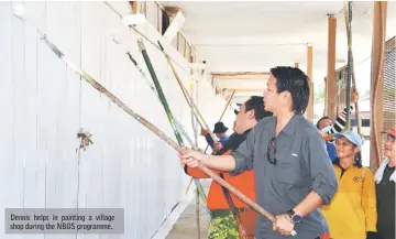  ??  ?? Dennis helps in painting a village shop during the NBOS programme.