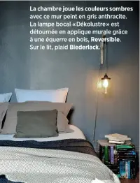  ??  ?? La chambre joue les couleurs sombres avec ce mur peint en gris anthracite. La lampe bocal «Dékolustre» est détournée en applique murale grâce à une équerre en bois, Reversible.Sur le lit, plaid Biederlack.