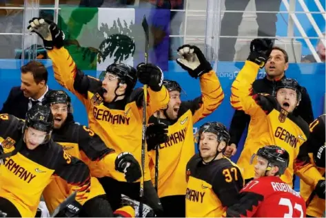  ??  ?? Canadian defenceman Mat Robinson of Calgary gets a front- seat view of the enthusiast­ic German celebratio­n after the underdogs defeated Canada 4- 3 in their semifinal match to advance to the gold- medal game against the Olympic Athletes from Russia....