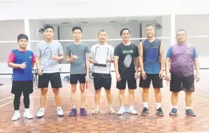  ?? ?? KENANGAN: John (kanan) merakamkan gambar kenangan bersama beberapa peserta dalam pertanding­an badminton yang diadakan baru-baru ini.