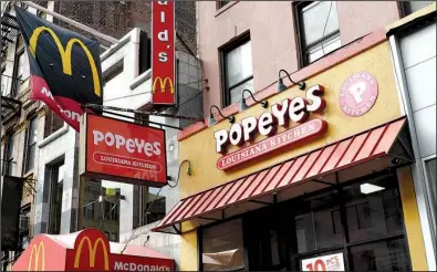  ?? AP/MARK LENNIHAN ?? A Popeyes fast food restaurant stands next door to a McDonald’s in the Brooklyn borough of New York earlier this month. Restaurant Brands Internatio­nal, the parent company of Burger King and Tim Hortons, is buying Popeyes.