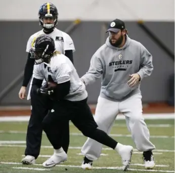  ?? GENE J. PUSKAR/THE ASSOCIATED PRESS ?? Injured Steelers QB Ben Roethlisbe­rger, right, hands off during practice Thursday. He is listed as day to day.