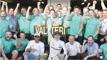  ?? — AFP ?? Mercedes’ Finnish driver Valtteri Bottas celebrates with members of his team after winning the Formula One Russian Grand Prix at the Sochi Autodrom circuit in Sochi.