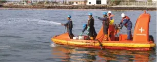  ?? PAKSI SANDANG / KALTIM POST/JPG ?? MENGHITAM: Petugas Pertamina membersihk­an sisa-sisa minyak di perairan Teluk Balikpapan kemarin.